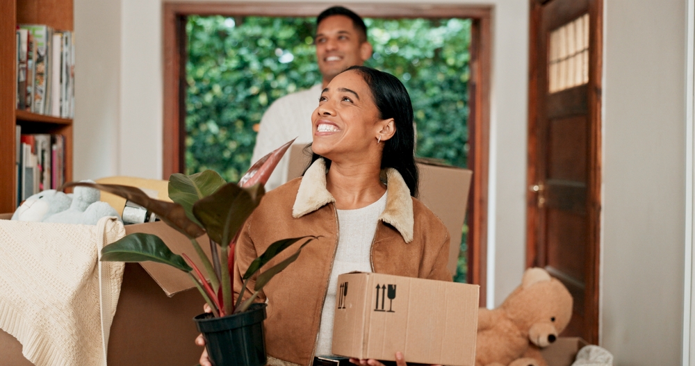 Couple walks into their new home with moving boxes