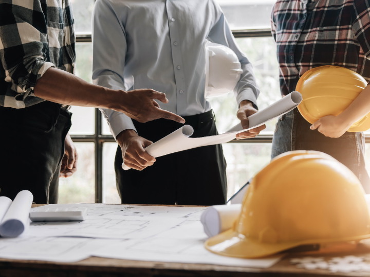 Meeting with blueprints and hard hats - commercial real estate