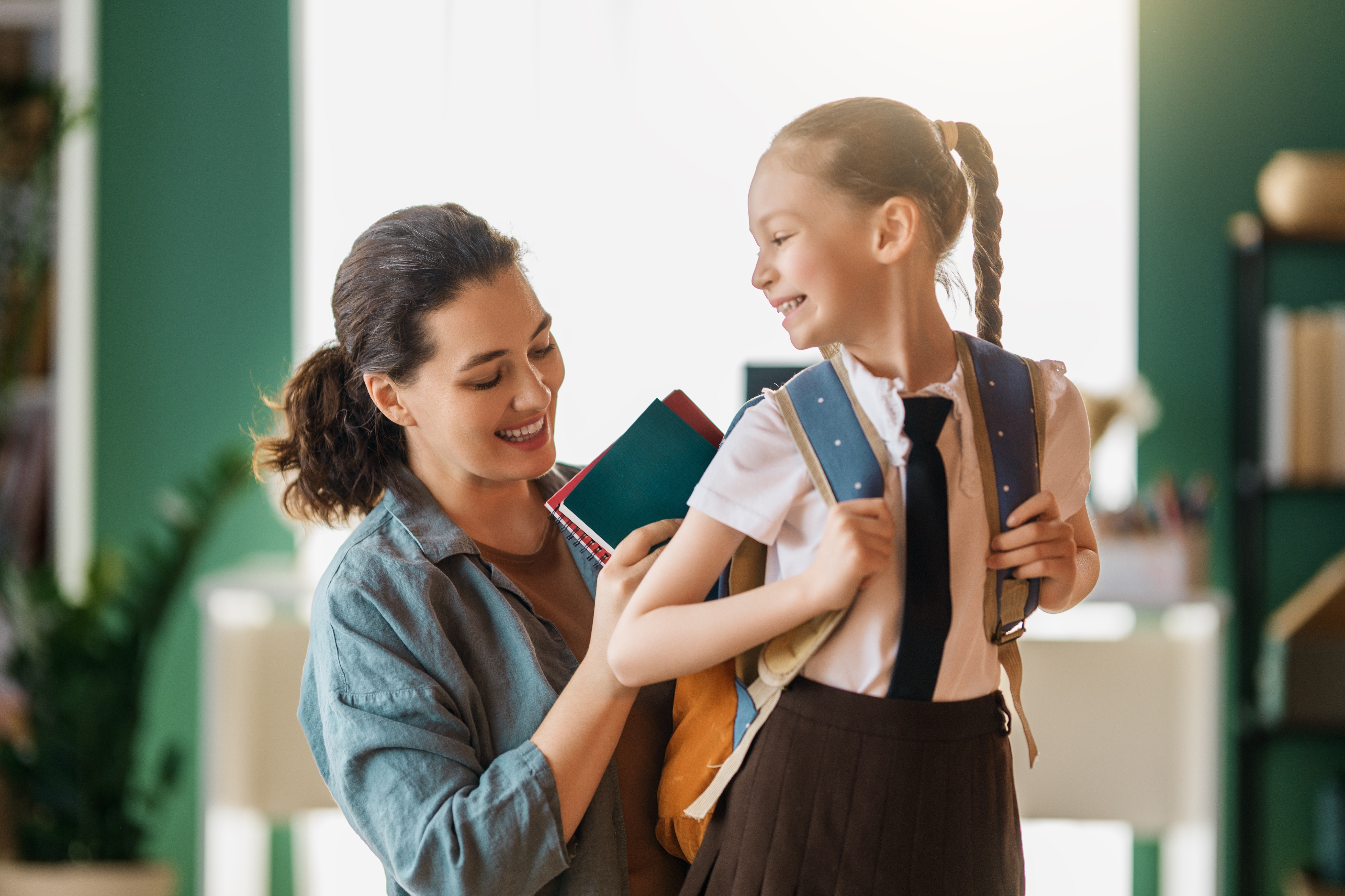 Mom adjusts daughter's backpack first day of school