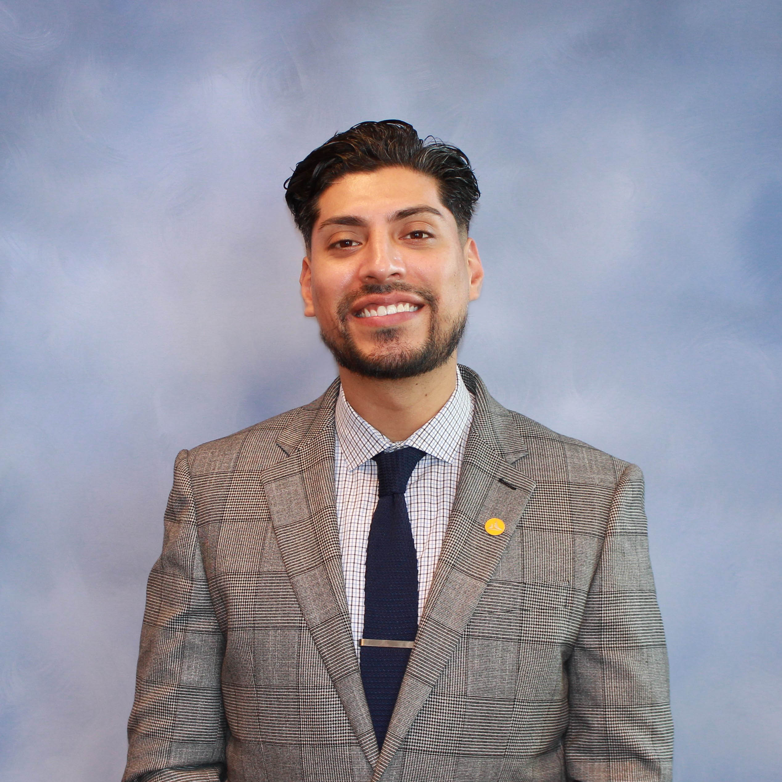 Formal headshot of a branch manager, seated at their desk in a business environment