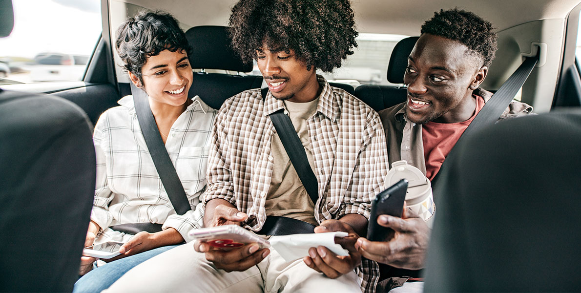 Three people sitting in the back of the car making Zelle transactions