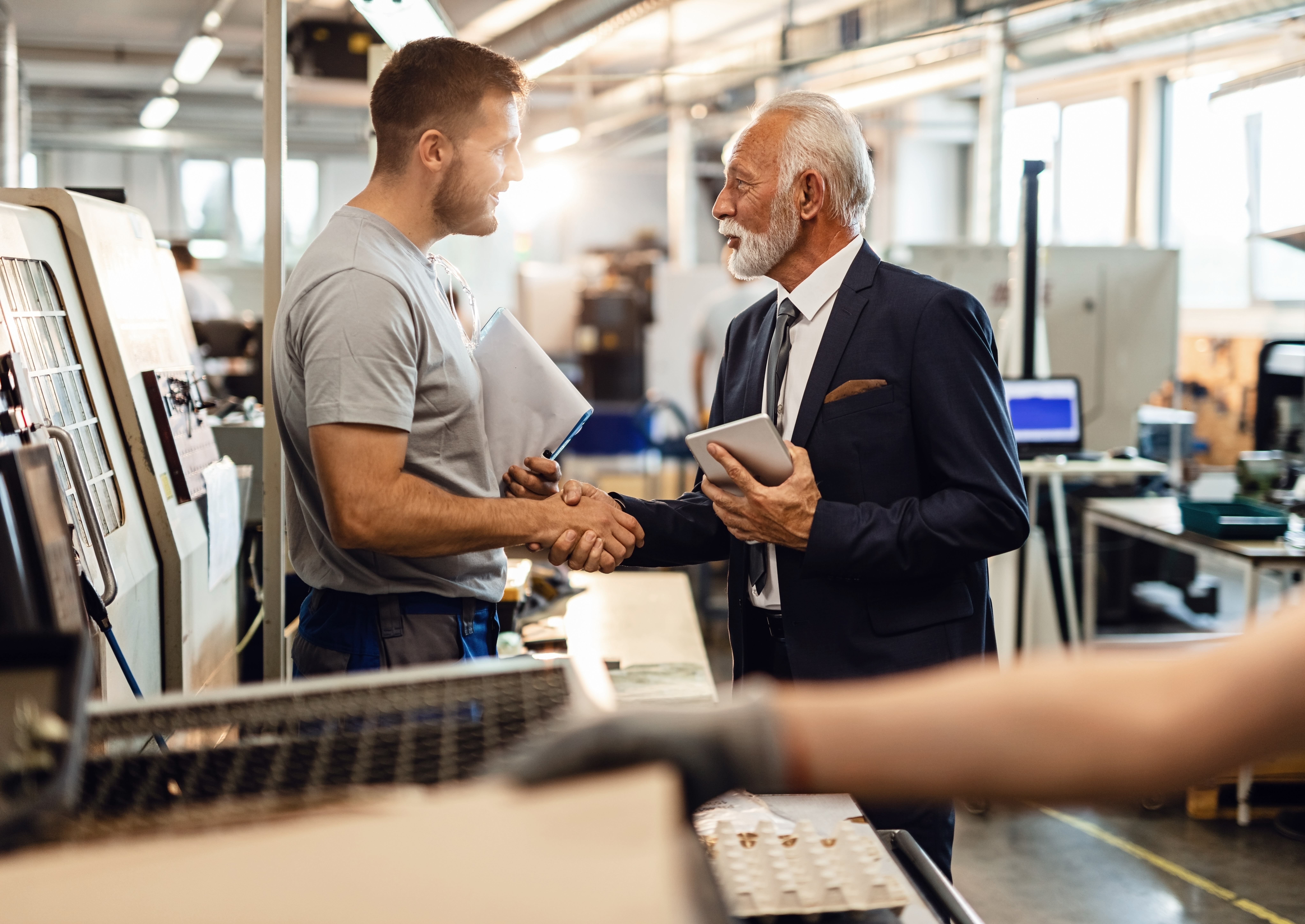 Banker and business owner shaking hands in place of business