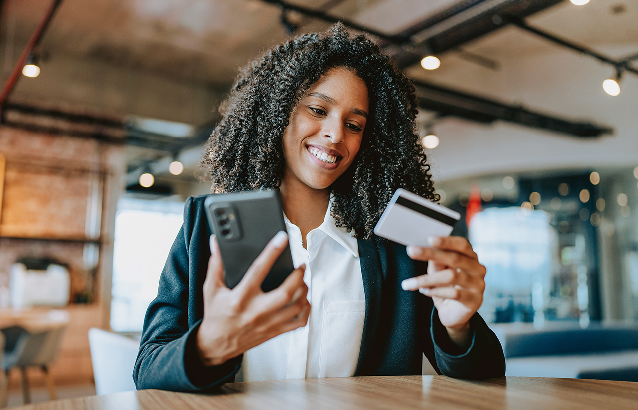 a woman holding a credit card and smiling