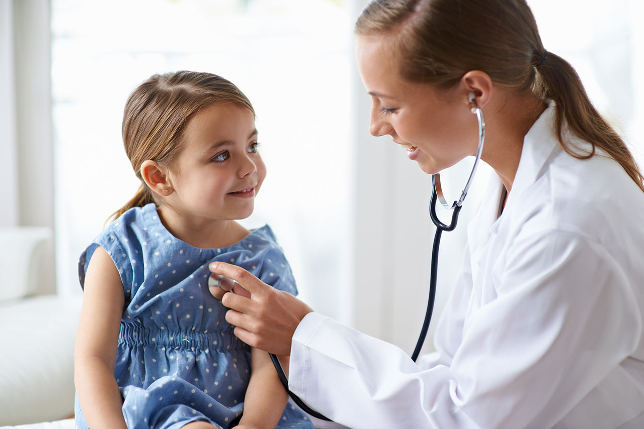 a little girl is being examined by a doctor