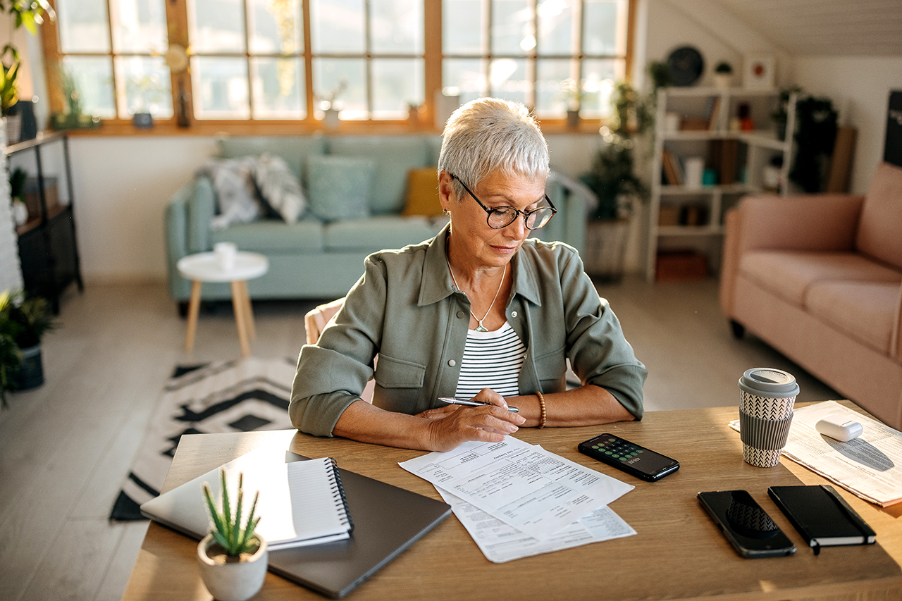 woman working at a desk with papers and a coffee mug