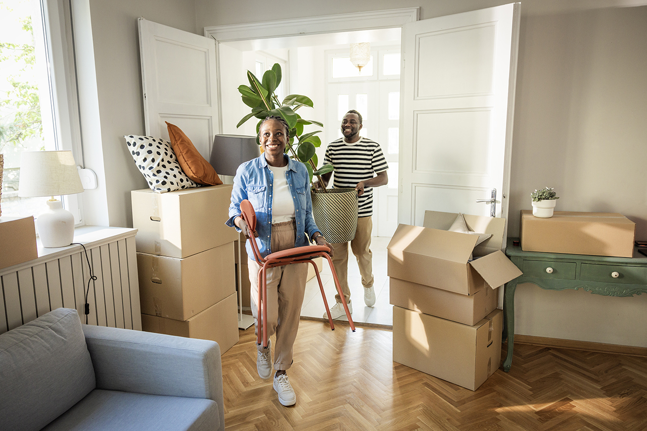 Family unpacking boxes in a newly moved-in home, smiling together