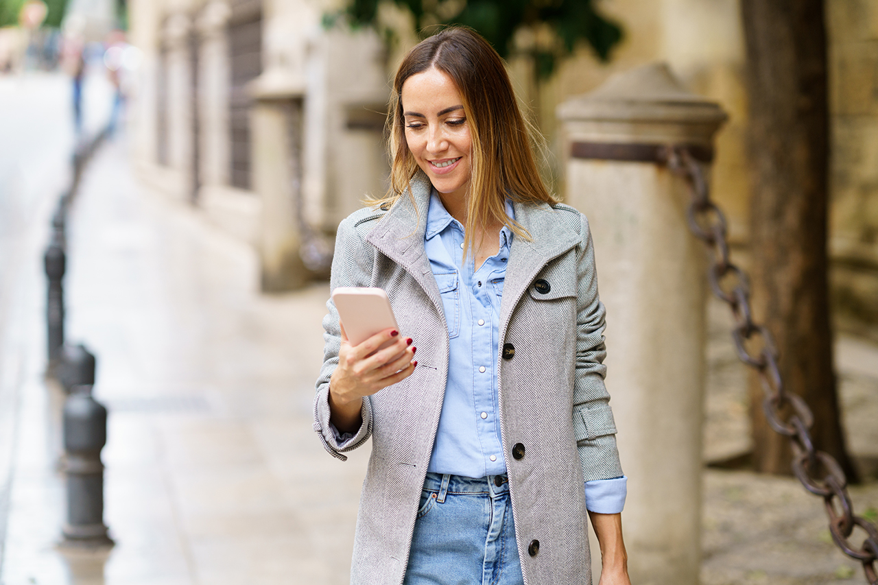 women walking and looking at phone