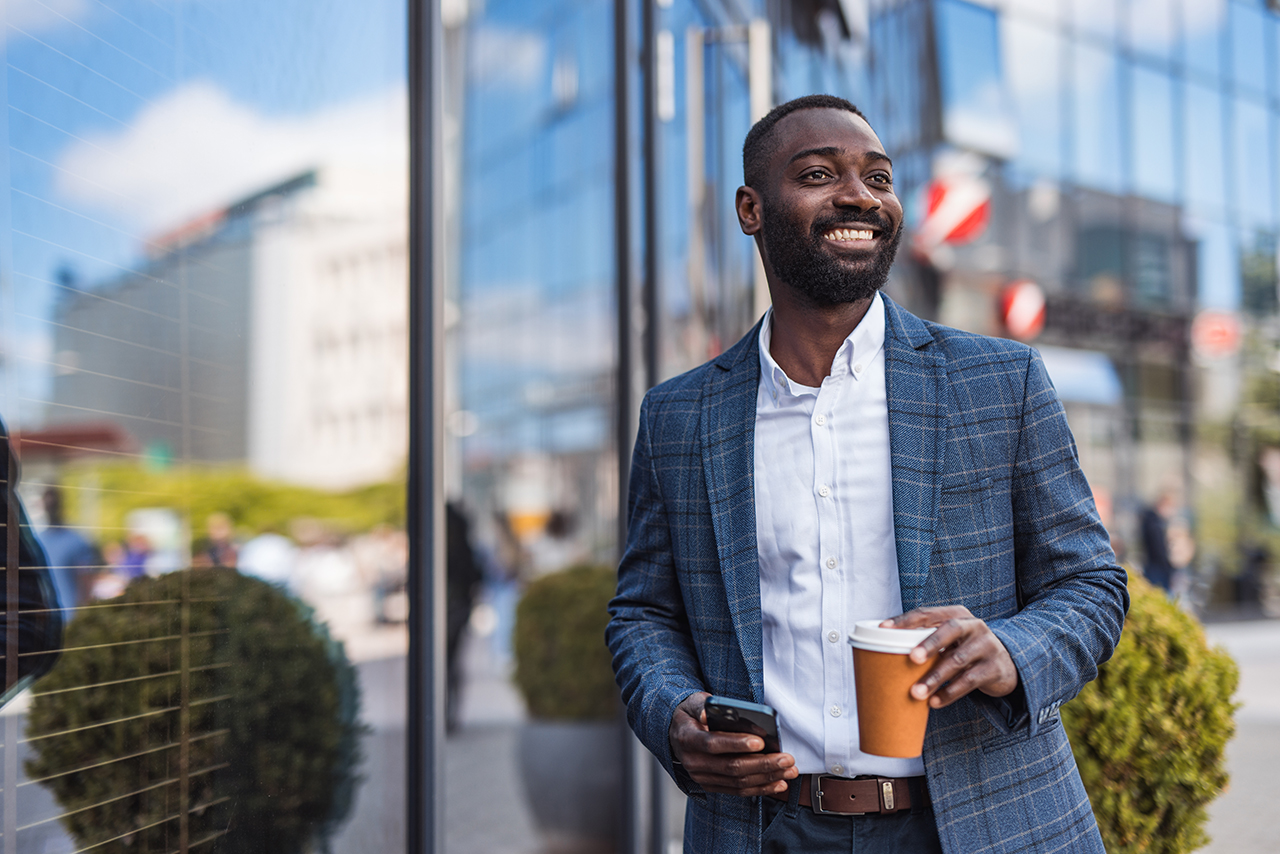 businessman walking outside holding a coffee
