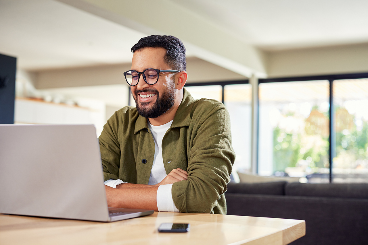 man smiling typing on the computer