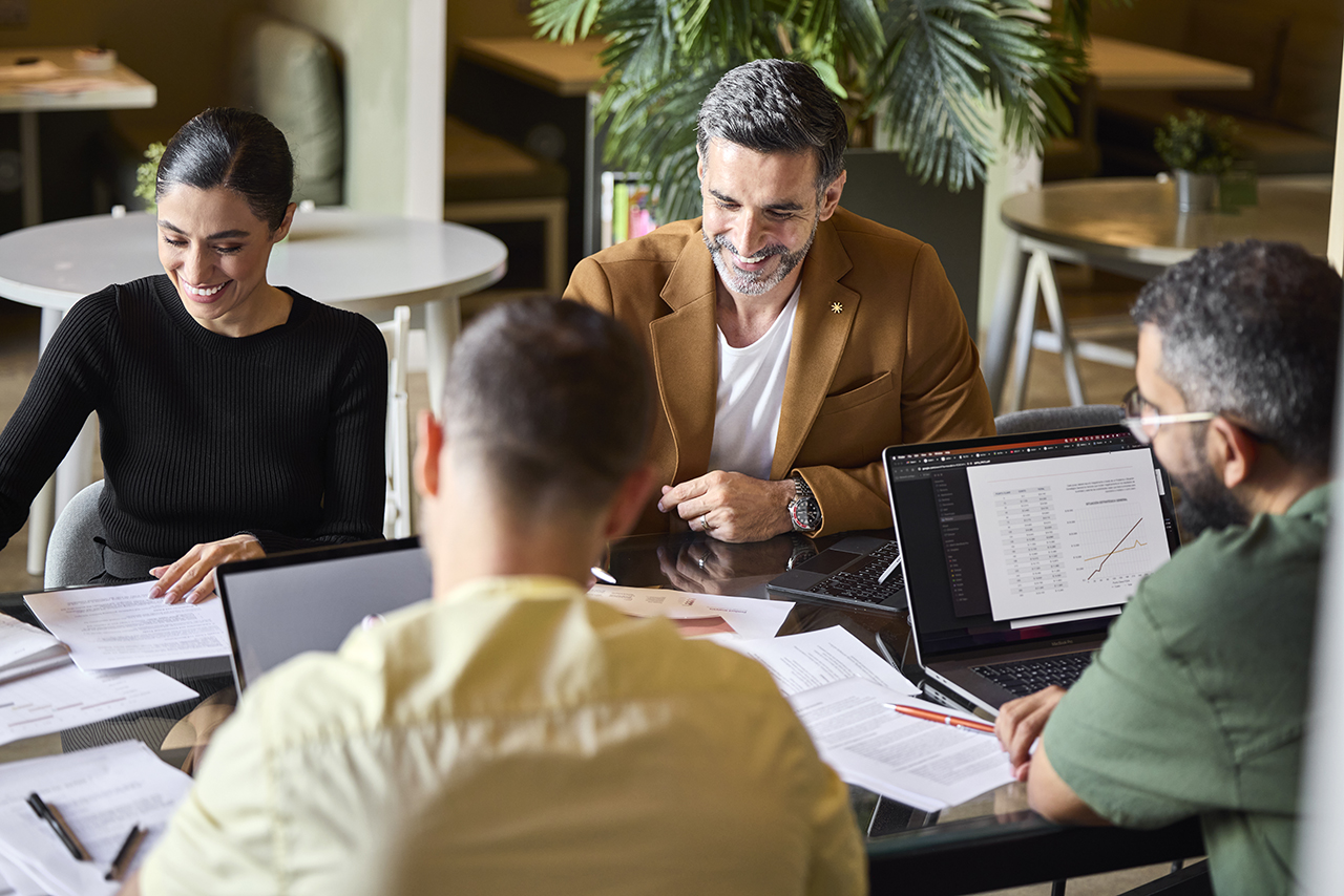 Group of professionals sitting at a table in a meeting, discussing and collaborating