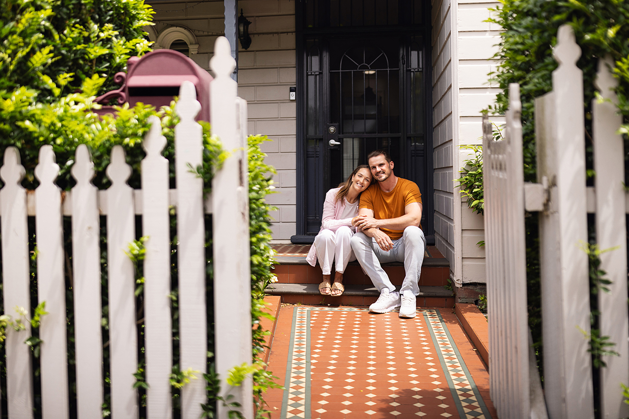 Family sitting on their front step smiling