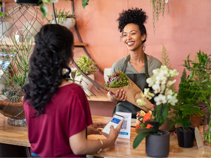 African American business owner in her florist shop talking to customer